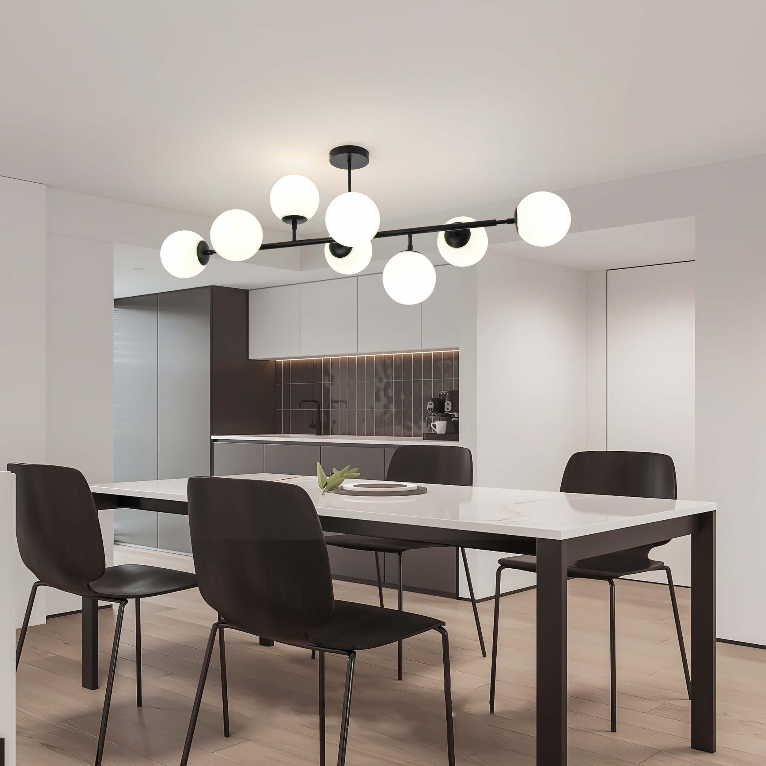 Designerska lampa z ośmioma mlecznymi kulami zawieszona nad prostokątnym stołem w nowoczesnej, minimalistycznej kuchni.